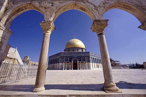 The Dome of the Rock in Jerusalem, seen through a stone archway